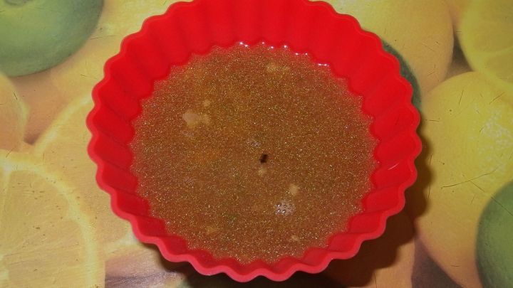 Eine rote Silikonform enth&auml;lt eine br&auml;unliche Fl&uuml;ssigkeit, die zum praktischen Portionieren von Suppe eingefroren wird.