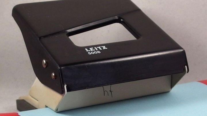 Der schwarze Locher liegt auf einem Farbdokument und ist bereit, Klarsichth&uuml;llen zu lochen.