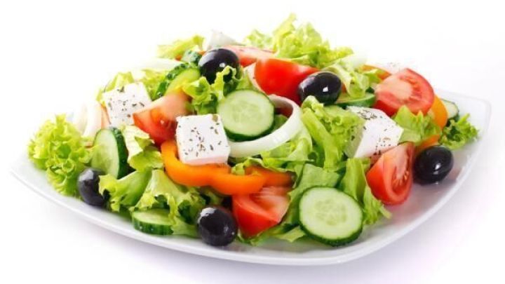 Frischer Salat auf einem Teller zeigt bunte Zutaten wie Gurken, Tomaten und Feta, ideal f&uuml;r fettl&ouml;sliche Vitamine.