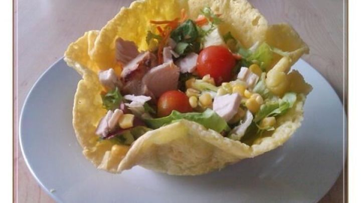 K&auml;seschale mit frischem Salat gef&uuml;llt: Tomaten, Mais und H&auml;hnchenst&uuml;cke auf einem wei&szlig;en Teller.