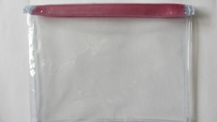 Ein transparenter Beutel sch&uuml;tzt einen E-Book-Reader vor Sand, ideal f&uuml;r Strand- oder Outdoor-Aktivit&auml;ten.