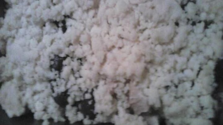 Ein Birnen-Crumble liegt in einer Backform, der Teig aus Kr&uuml;meln bedeckt den Boden ungleichm&auml;&szlig;ig, bereit zum Backen.