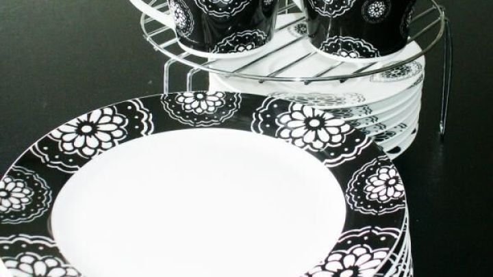 Ein Tellerst&auml;nder h&auml;lt gestapelte, schwarz-wei&szlig; gemusterte Teller und Tassen in einer K&uuml;che.