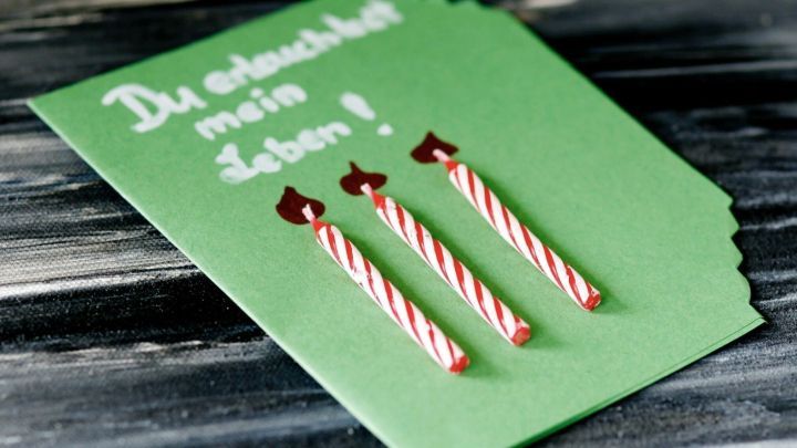 Eine gr&uuml;ne Geburtstagskarte zeigt drei Kerzen und den Text &bdquo;Du entscheidest mein Leben!&ldquo; in einem romantischen Kontext.