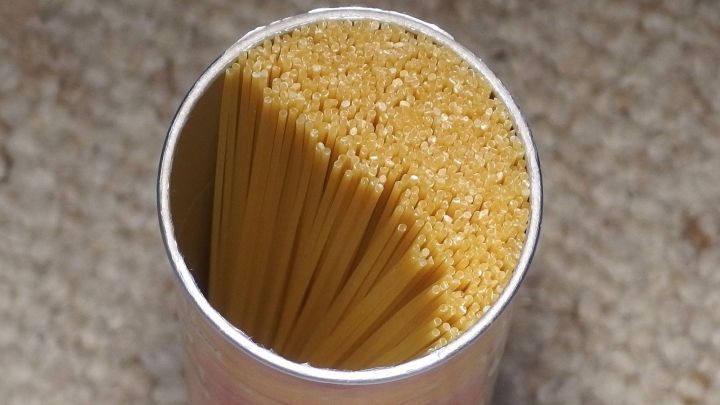 Ein runder Beh&auml;lter mit trockenen Spaghetti wird auf einem Teppich pr&auml;sentiert. Die Spaghetti stehen senkrecht im Beh&auml;lter.