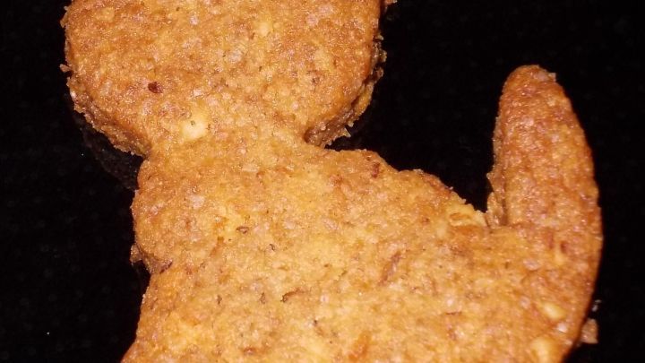 Kekse in Form einer Katze liegen auf einem schwarzen Hintergrund und vermitteln einen spielerischen Eindruck von Erdnussbutter.