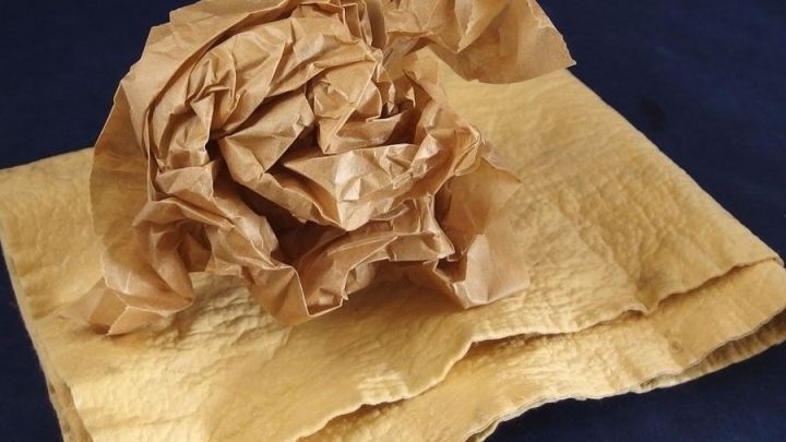 Ein zerkn&uuml;lltes, braunes Tuch liegt auf einem dunklen Untergrund, was als Ersatz f&uuml;r Fensterleder fungieren kann.