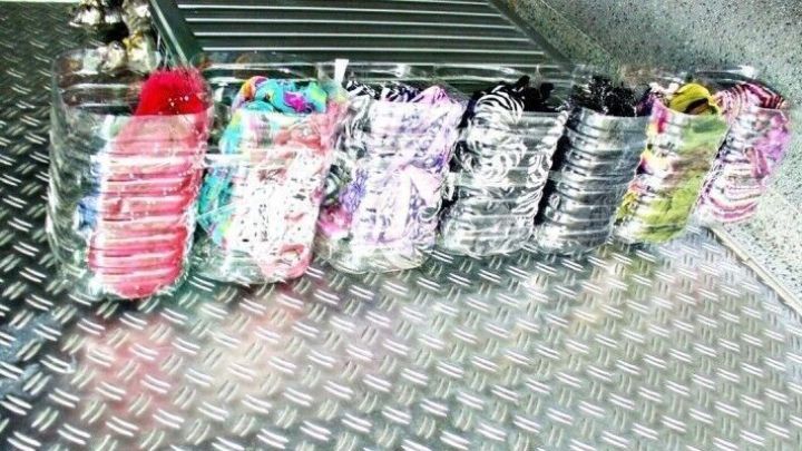 Bunte, pfandfreie Saftflaschen stehen ordentlich in einer Reihe auf einer glatten Metalloberfl&auml;che.