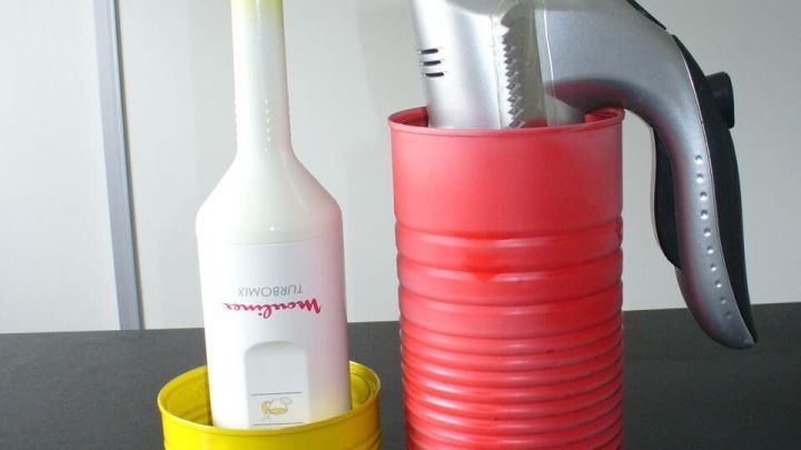 Mixer und Handmixer stehen in gelber und roter Dose, platzsparend auf einer dunklen Tischplatte, vor heller Wand.