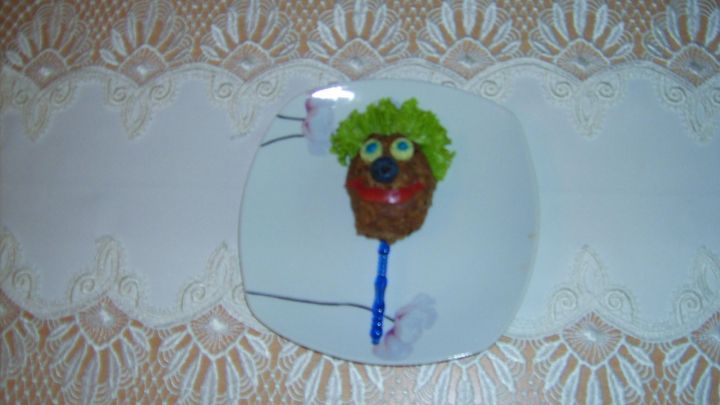 Hackgesicht mit Gem&uuml;se als Haare und Augen auf Teller, dekoriert auf Tischdecke. Datum: 12/07/2014 09:42.