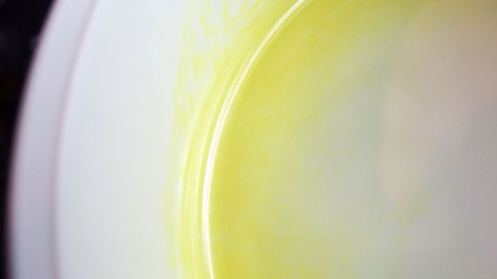 Eine Sch&uuml;ssel mit Verf&auml;rbungen zeigt einen Gelbstich auf der glatten Oberfl&auml;che, die im K&uuml;chenumfeld beleuchtet wird.