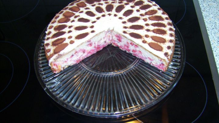 Ein Johannisbeerkuchen mit Muster wird auf einem Glasteller pr&auml;sentiert; ein St&uuml;ck fehlt. Am Rand ist das Datum 22/07/2014 12:19 auf einer Herdplatte zu sehen.