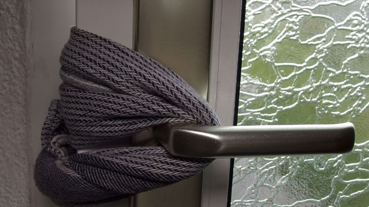 Ein graues Tuch ist um einen T&uuml;rgriff gewickelt, um zu verhindern, dass Kleinkinder sich die Finger quetschen.