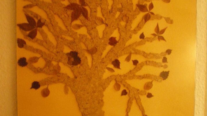 Ein Baum ist aus bunten Bl&auml;ttern gestaltet, umgeben von weiteren Bl&auml;ttern auf einem hellen Hintergrund.