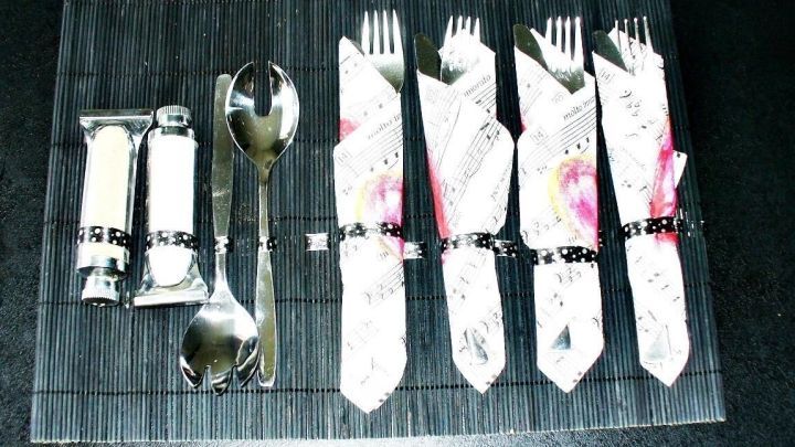 Ein schlichtes Tischset zeigt ordentlich eingepacktes Besteck, bereit f&uuml;r ein Picknick auf einem dunklen Untergrund.