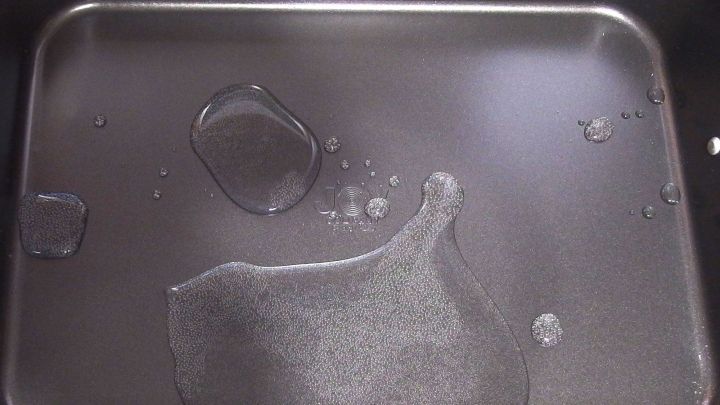 Ein Grillrost liegt in einer Pfanne, die mit Mineralwasser gef&uuml;llt ist, um die Reinigung zu erleichtern.