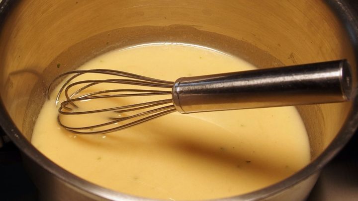 In einem Topf wird eine glatte Mehlschwitze zubereitet, w&auml;hrend ein Schneebesen r&uuml;hrend eingetaucht ist.