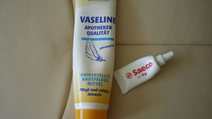 Ein Vaseline-Tube und eine kleine Saeco-Reparaturtube liegen auf einer beigefarbenen Oberfl&auml;che, bereit zur Anwendung und Pflege.