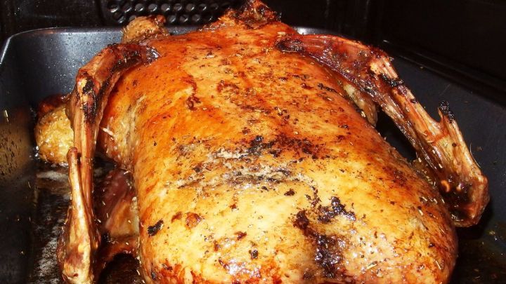 Ein goldbraun gebratenes Gefl&uuml;gel liegt in einer Auflaufform, bereit zum Servieren mit W&uuml;rzsalz f&uuml;r den Geschmack.