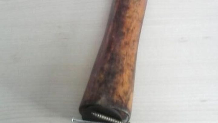 Ein Hammer mit einem langen, h&ouml;lzernen Griff liegt auf einer flachen Holzoberfl&auml;che, bereit zum Arbeiten mit N&auml;geln.