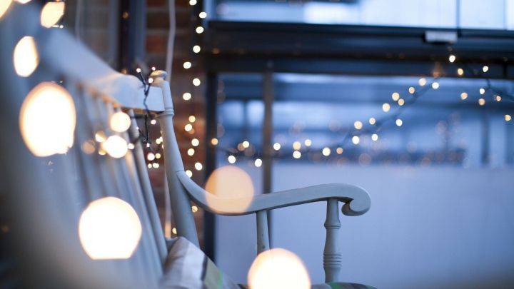 Ein Schaukelstuhl steht in einem Raum, beleuchtet von warmen Lichtern, die eine gem&uuml;tliche Atmosph&auml;re schaffen.