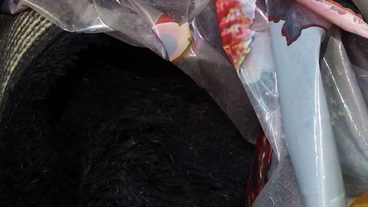 Langhaarige Badevorlagen liegen in einer abgedeckten Tasche, bereit f&uuml;r eine fusselfreie W&auml;sche in einem trockenen Raum.