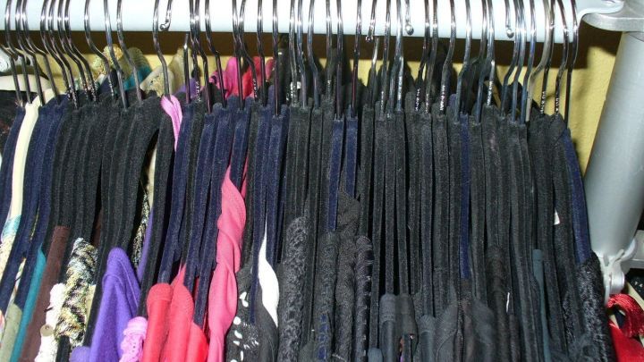 Ein Kleiderst&auml;nder mit selten getragenen Kleidungsst&uuml;cken zeigt viele schwarze Blusen und Tops, die ordentlich aufgeh&auml;ngt sind.