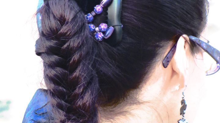 Ein Haarwachs wird auf einen geflochtenen Zopf aufgetragen, um den Stil zu fixieren und zu sch&uuml;tzen.