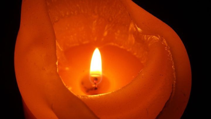 Eine brennende Kerze im Dunkeln, deren Wachs sich verfl&uuml;ssigt und an einer Form anh&auml;ngt, k&ouml;nnte schwierig zu entfernen sein.