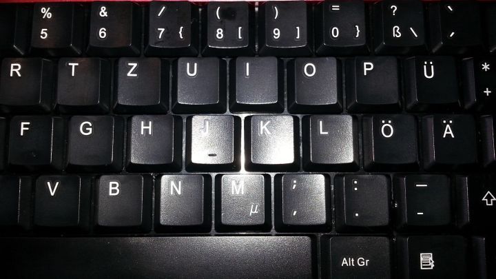 Eine verklebte PC-Tastatur mit hervorgehobenen Tasten zeigt Schmutz und Ablagerungen, die dringend gereinigt werden m&uuml;ssen.