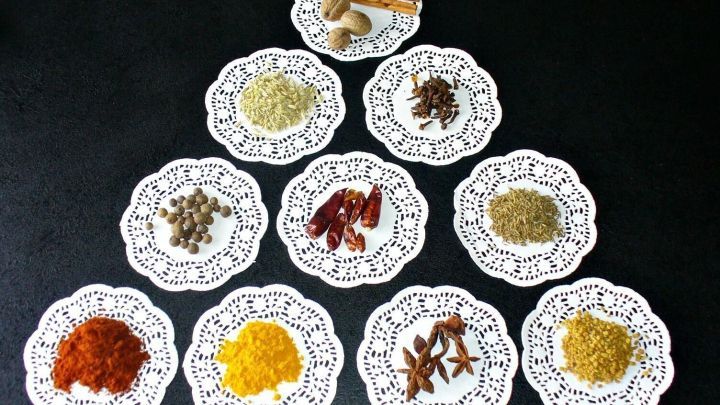 Eine Auswahl an w&uuml;rzigen Mischungen ist auf dekorativen Tellern angeordnet, um internationale Gerichte zu verfeinern.