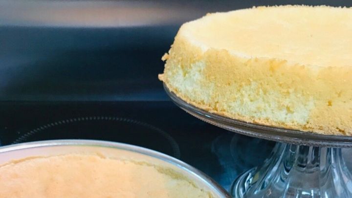 Ein goldbrauner Sahnebiskuit steht in einer runden Form, w&auml;hrend ein weiterer auf einem Tortenst&auml;nder pr&auml;sentiert wird.