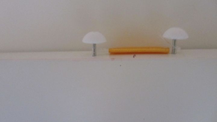 Eine wei&szlig;e Wohnungst&uuml;r mit zwei Halterungen und einem senkrechten Deko-Element in der Mitte, bereit zur Dekoration.