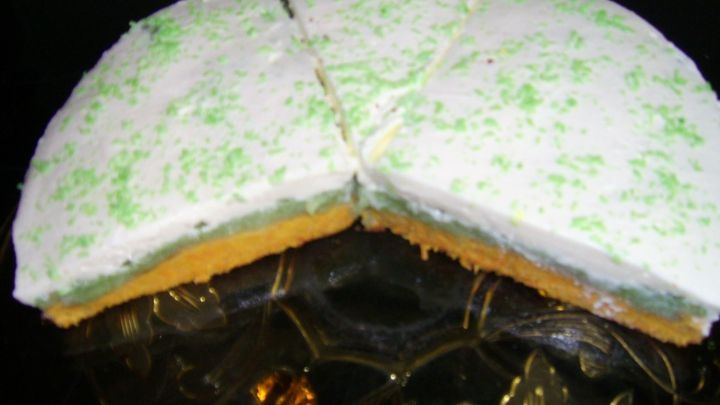 Eine M&ouml;hren-Apfel-Torte liegt auf einem dekorativen Teller, auf dem mehrere St&uuml;cke gleichm&auml;&szlig;ig geschnitten sind.