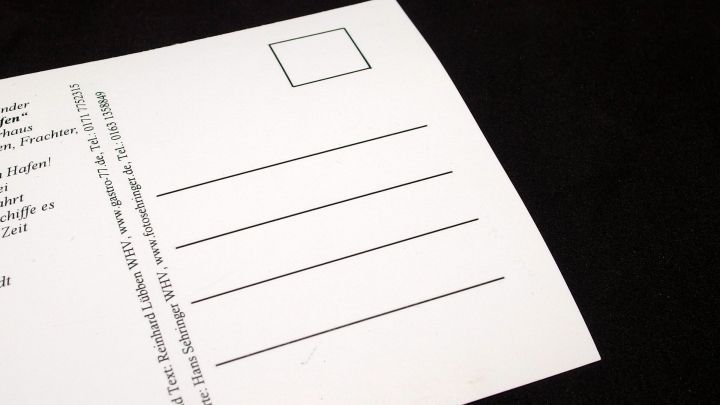 Eine unbeschriebene Postkarte liegt auf einem schwarzen Untergrund und wartet darauf, f&uuml;r Briefe verwendet zu werden.