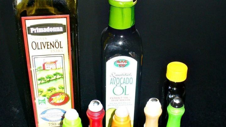 Eine Sammlung von leeren Roll-on-Stiften steht neben zwei Flaschen &Ouml;l auf einem Tisch, bereit zur Wiederverwendung.