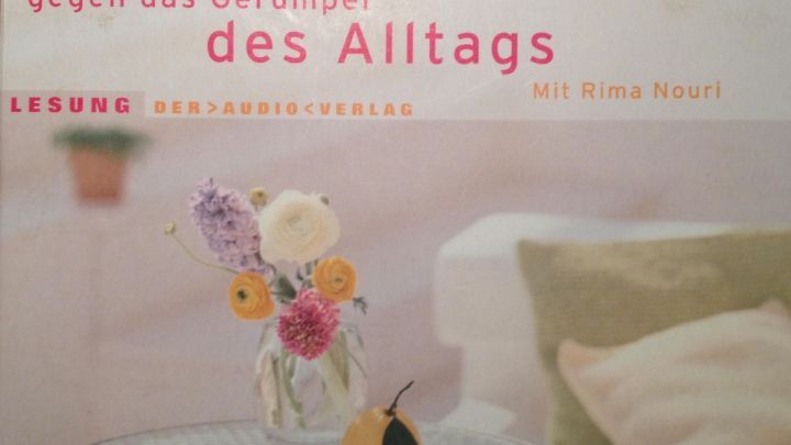 Ein Buch &uuml;ber Feng Shui gegen das Ger&uuml;mpel des Alltags liegt auf einem Tisch, umgeben von einer gem&uuml;tlichen Atmosph&auml;re.