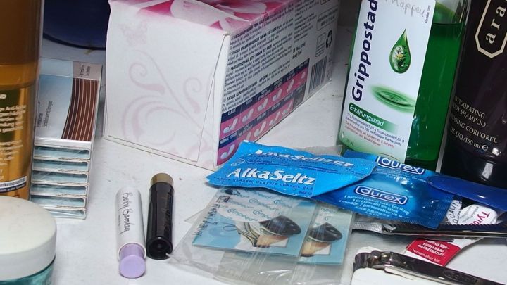 Ein &uuml;berf&uuml;llter Badschrank zeigt Produkte wie Cremes und Medikamente, die unordentlich gestapelt sind und Platz ben&ouml;tigen.