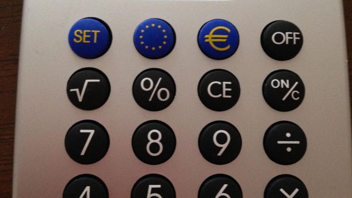 Ein Taschenrechner zeigt auf dem Display eine Zahl an und liegt auf einer Holzoberfl&auml;che. Der Benutzer k&ouml;nnte Berechnungen durchf&uuml;hren.