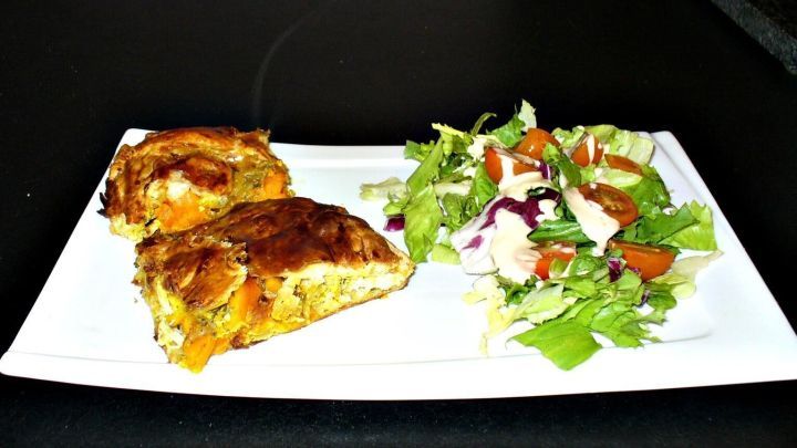 Zwei St&uuml;ck K&uuml;rbisstrudel liegen auf einem Teller, daneben ein frischer Salat in einer ansprechenden Gr&uuml;nt&ouml;nung.