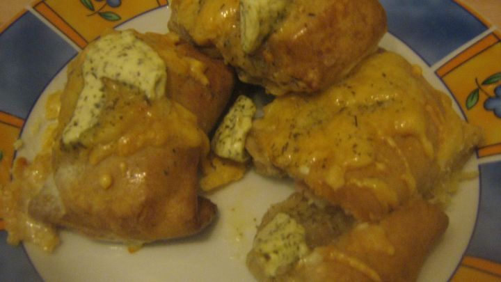 K&auml;sebr&ouml;tchen liegen auf einem bunten Teller, sind goldbraun gebacken und mit schmelzendem K&auml;se gef&uuml;llt.