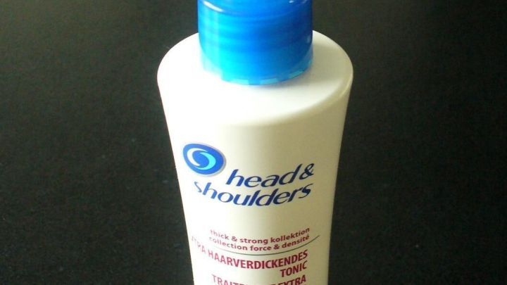 Ein Tonic von Head & Shoulders steht auf einem dunklen Tisch und dient der Haarverdickung f&uuml;r d&uuml;nnes, lichtes Haar.