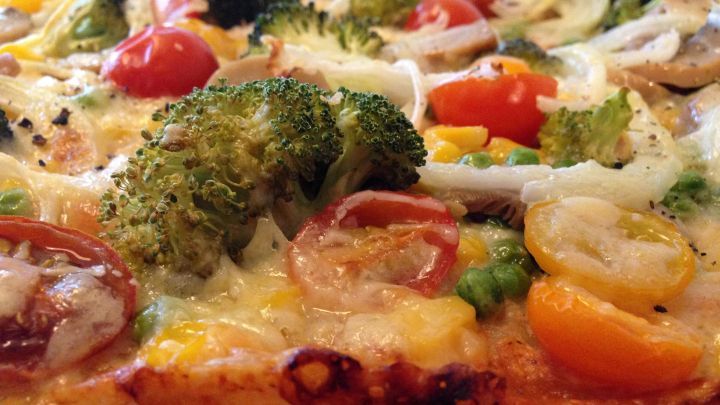 Ein vegetarischer Gem&uuml;se-Bl&auml;tterteigkuchen mit buntem Gem&uuml;se wie Brokkoli und Kirschtomaten in einer k&ouml;stlichen Ansicht.