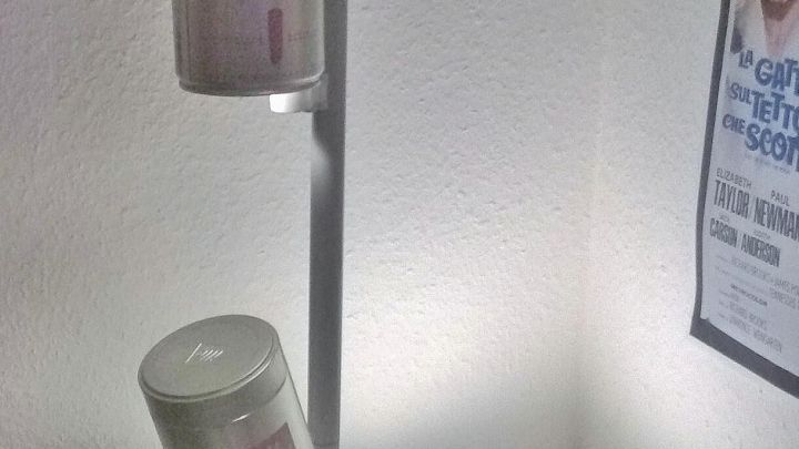 Eine Stehlampe aus Metall mit drei leuchtenden Gl&auml;sern steht in einem Raum und bietet modernes Lichtdesign.