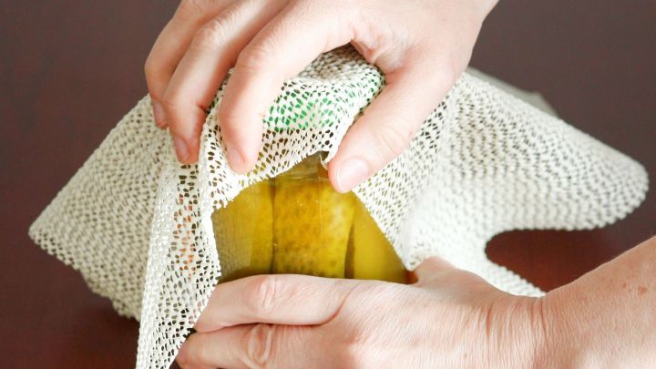 Ein Glas mit Gurken wird mit einer Antirutschmatte in einer Hand gehalten, w&auml;hrend die andere Hand die Matte strafft.