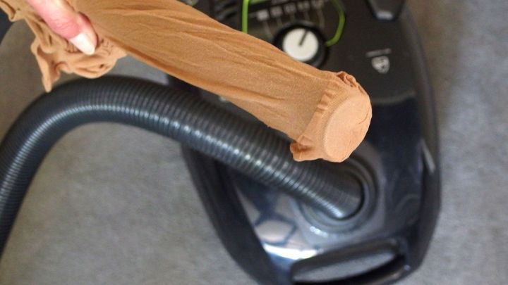 Ein Staubsauger wird benutzt, um kleine Teile wie Ohrringe aufzunehmen, w&auml;hrend ein Socken &uuml;ber das Schlauchende gezogen wird.