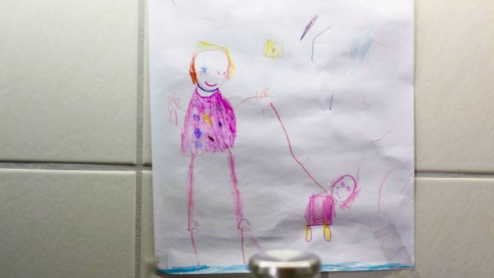 Ein farbenfrohes Kinderbild h&auml;ngt an einer Wand &uuml;ber einem Topf auf dem Herd, w&auml;hrend es kocht.