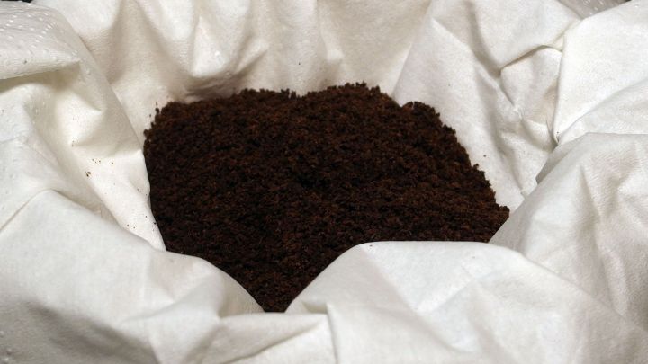 In einem Kaffeefilter liegen frisch gemahlene Kaffeebohnen, die zum Br&uuml;hen in einer K&uuml;che vorbereitet werden.