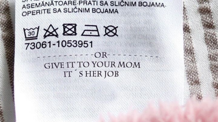Das Pflegeetikett zeigt Wasch- und Pflegehinweise f&uuml;r ein Textil, darunter die Anweisung: &bdquo;Give it to your mom. It's her job.&ldquo;