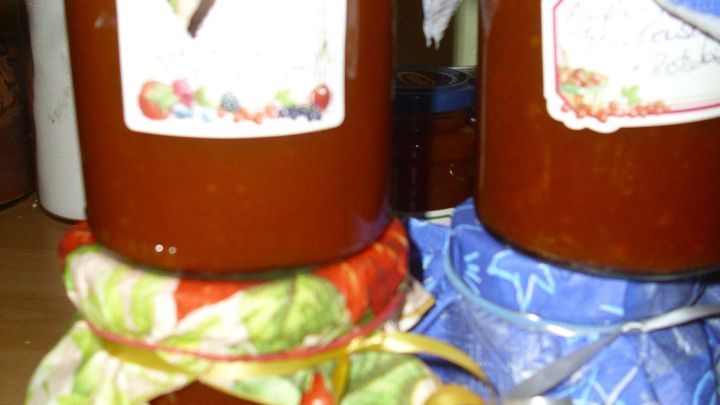 Zwei Gl&auml;ser mit Apfel-K&uuml;rbis Marmelade stehen auf einem Tisch, dekorativ mit bunten Stoffdeckeln und Etiketten versehen.